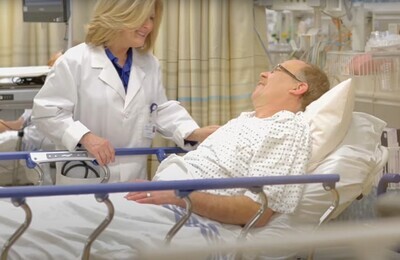Врач беседует с пациентом в больничной палате
